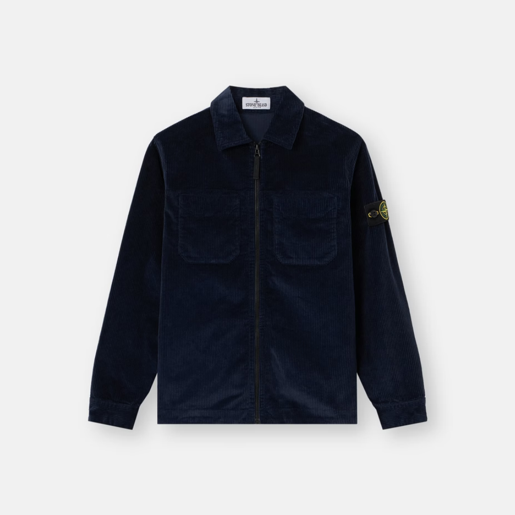 A dark navy blue corduroy jacket with a front zipper, two chest pockets, and the iconic Stone Island compass patch on the left sleeve, displayed on a clean light gray background.