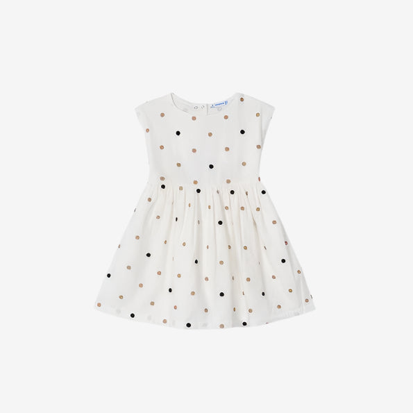 White dress with black and gold polka dots on a white background
