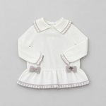 A white long-sleeve baby dress with a Peter Pan collar, delicate lace trim, and two small gray bows on the ruffled hem, displayed flat on a light gray background.