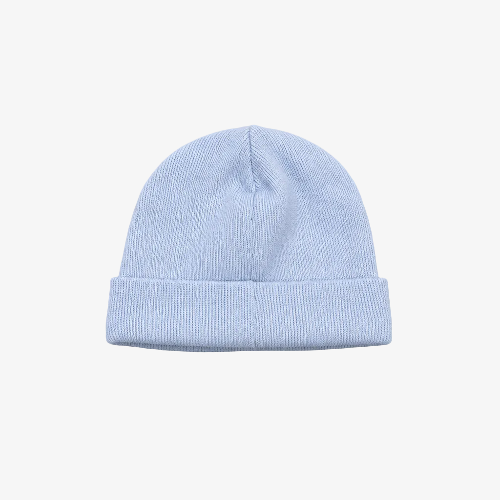 A light blue ribbed knit beanie hat with a folded cuff, centered on a neutral gray background.