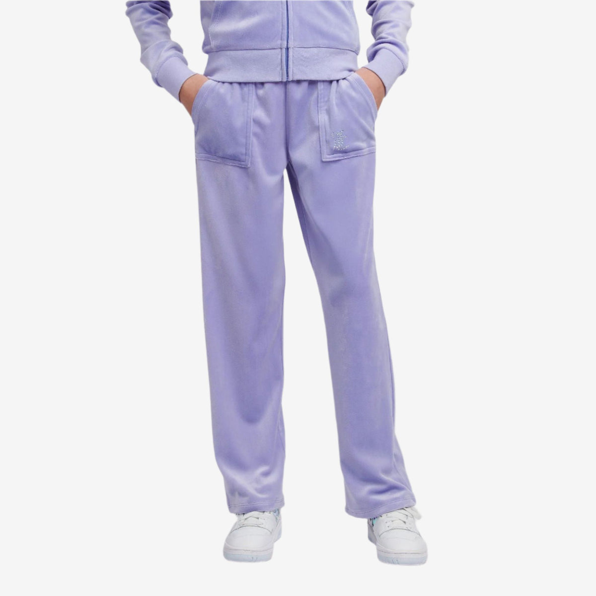 Person wearing a lavender tracksuit on a light gray background