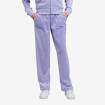 Person wearing a lavender tracksuit on a light gray background