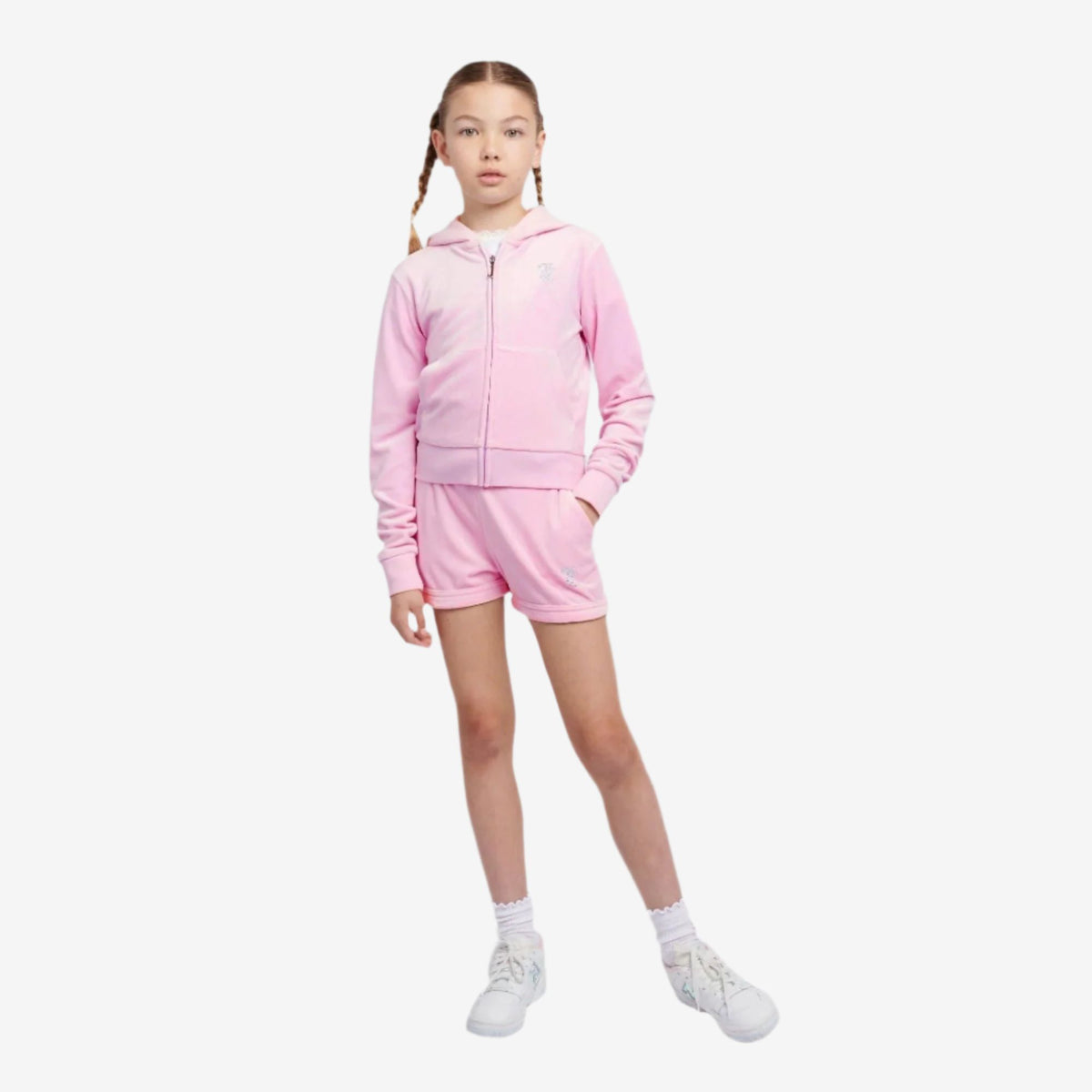 Young girl wearing a pink tracksuit on a white background