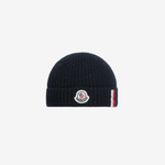 Navy blue beanie with a brand logo on a white background