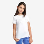 Young girl wearing a white t-shirt with a design on a plain background