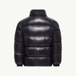 A black puffer jacket shown from the back, featuring horizontal quilting and a high collar, set against a plain off-white background.