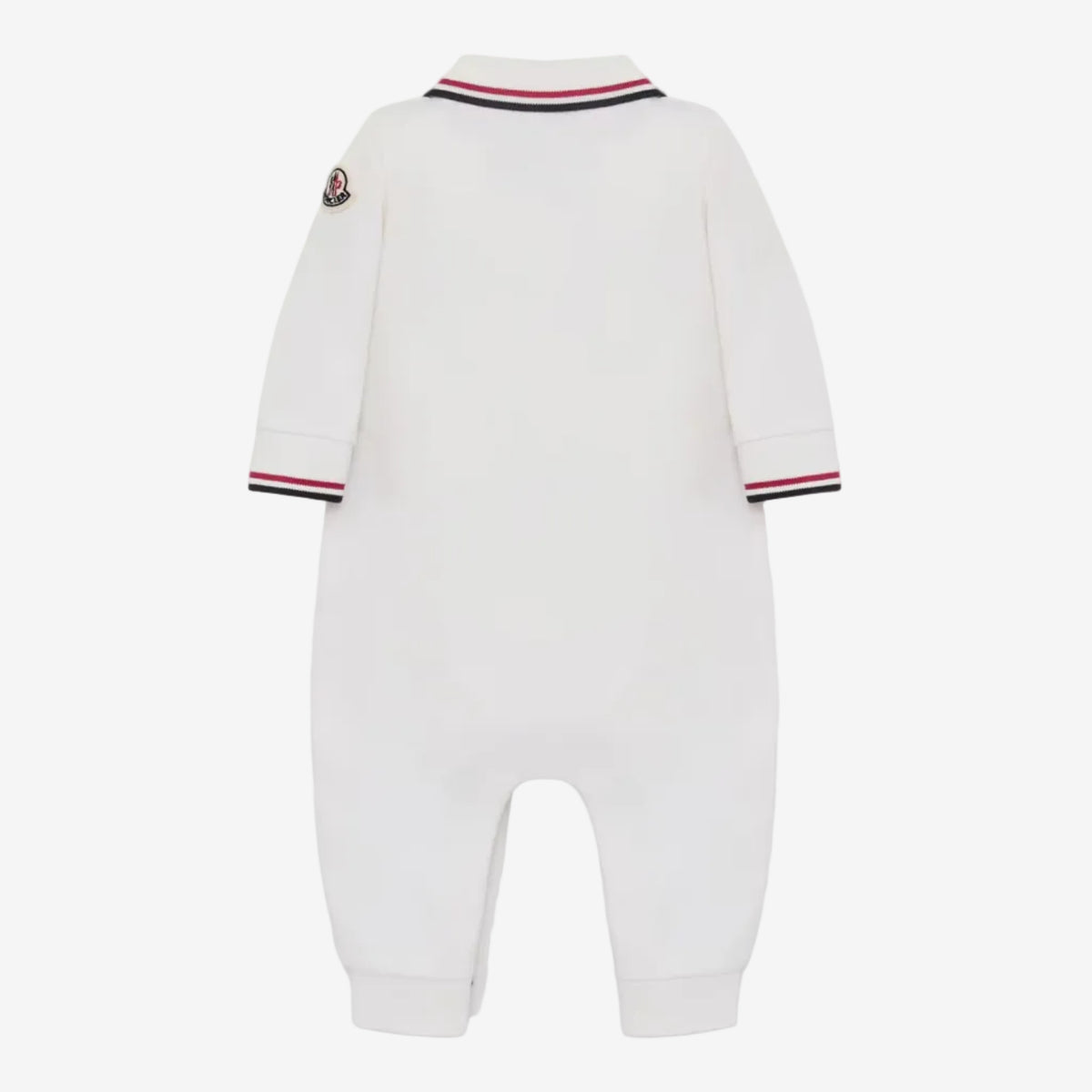 White long-sleeve baby jumpsuit shown from the back, featuring a striped collar and cuffs in navy, red, and white, with a small embroidered logo patch on the upper left shoulder.