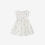 White dress with black and gold polka dots on a white background