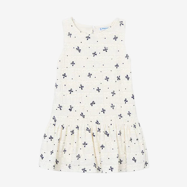 White sleeveless dress with small black floral pattern on a white background