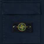 Close-up of a dark navy blue fabric pocket with a rectangular Stone Island logo patch on the front, featuring the brand's compass logo in yellow, green, and black.