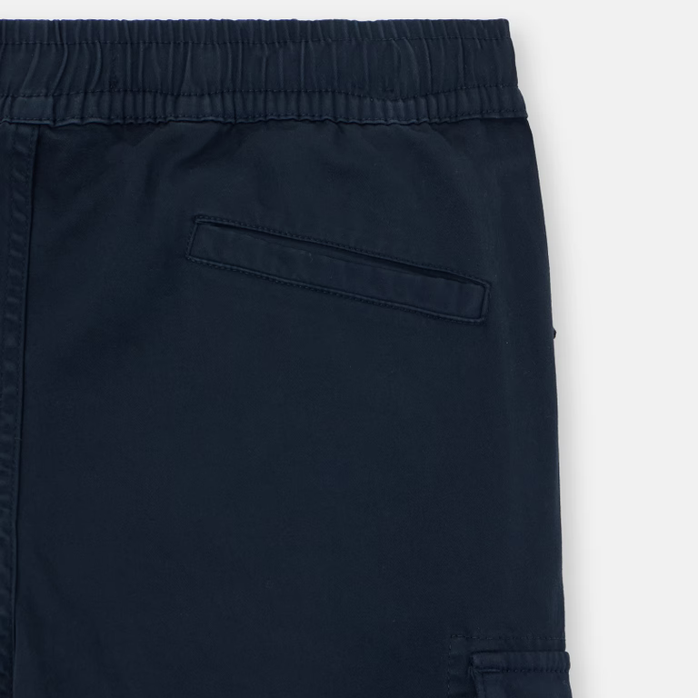 Close-up of dark navy blue pants showing the elastic waistband, a side pocket, and cargo-style flap pocket on the leg.