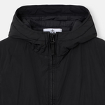 Close-up of a black hooded puffer jacket with a front zipper and a visible Stone Island neck label, shot against a light gray background.