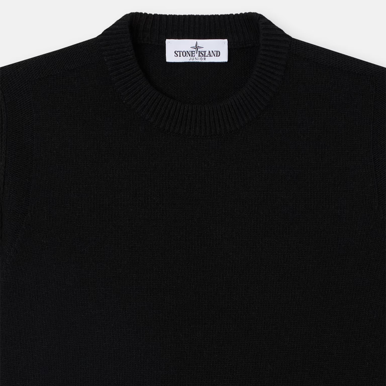 Close-up of a black knit crewneck sweater with a white Stone Island neck label.