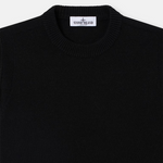 Close-up of a black knit crewneck sweater with a white Stone Island neck label.