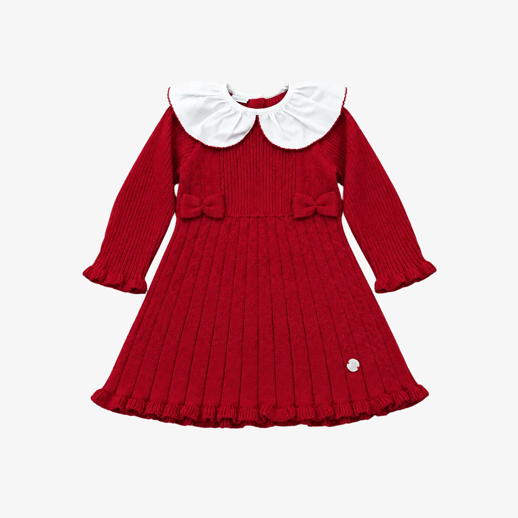 A red ribbed knit long-sleeve dress for toddlers, featuring a large white Peter Pan collar, matching red bows on the chest, and a pleated skirt, shown flat on a light gray background.