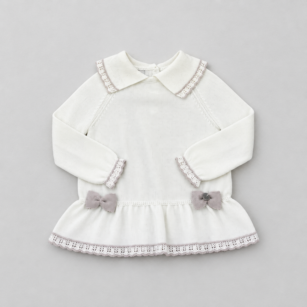 A white long-sleeve baby dress with a Peter Pan collar, delicate lace trim, and two small gray bows on the ruffled hem, displayed flat on a light gray background.