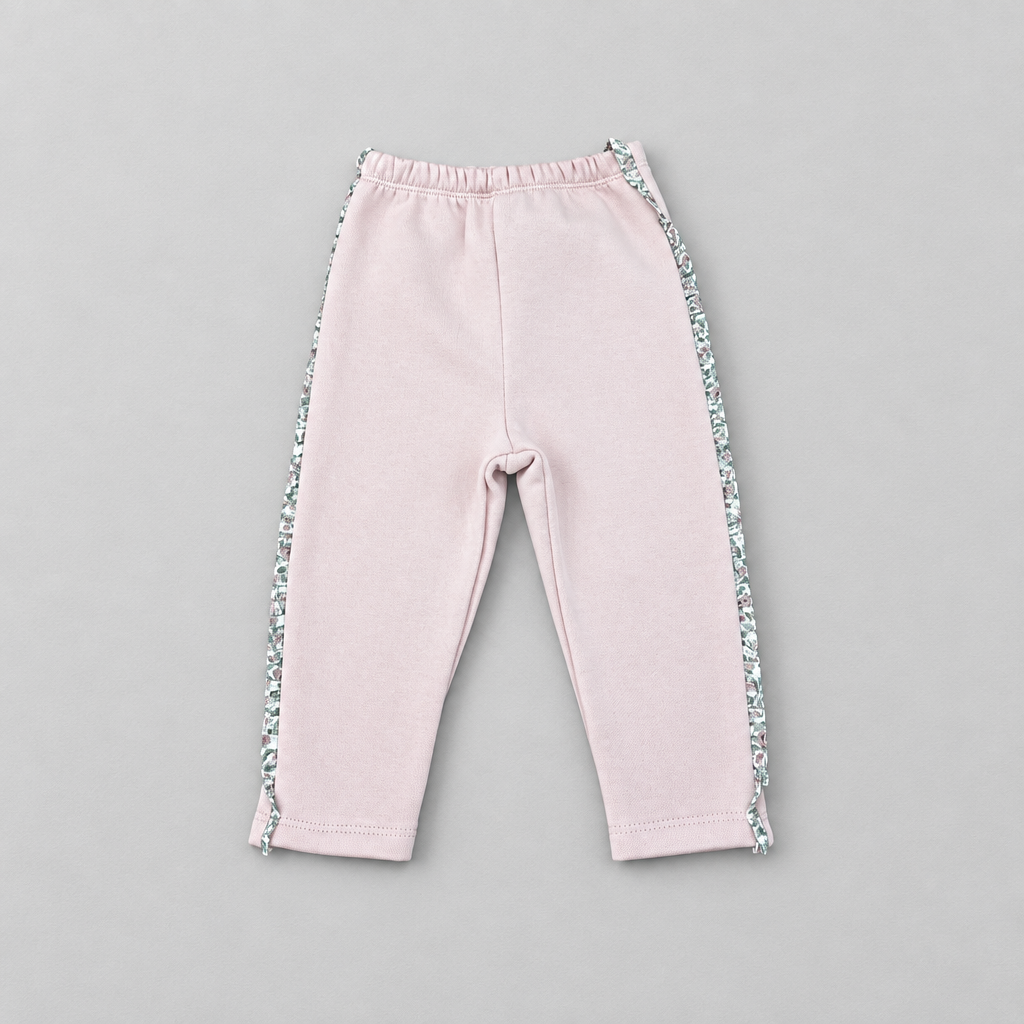 A pair of toddler's light pink sweatpants with a floral patterned side stripe, laid flat on a neutral gray background.