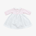 A baby girl's long-sleeve dress with a light pink bodice, white ruffled collar, and a white flared skirt, laid flat on a neutral gray background.