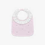 A light pink baby bib with a white ruffled collar and small embroidered details, shown on a neutral gray background.