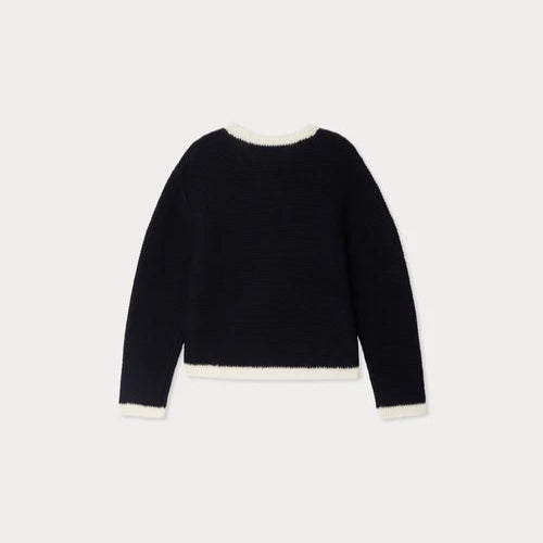 Black sweater with white trim on a light gray background